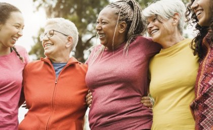 Group of women with arms around each other.